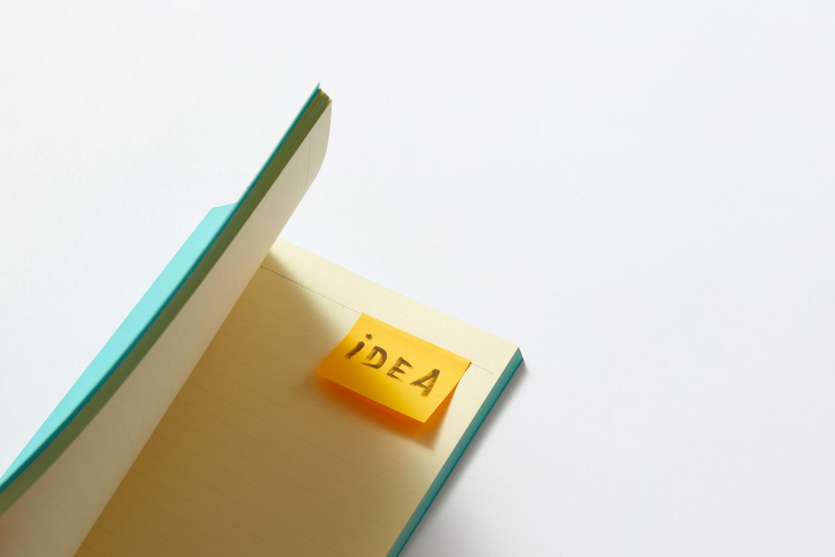 An open notebook with a yellow sticky note marked Idea.