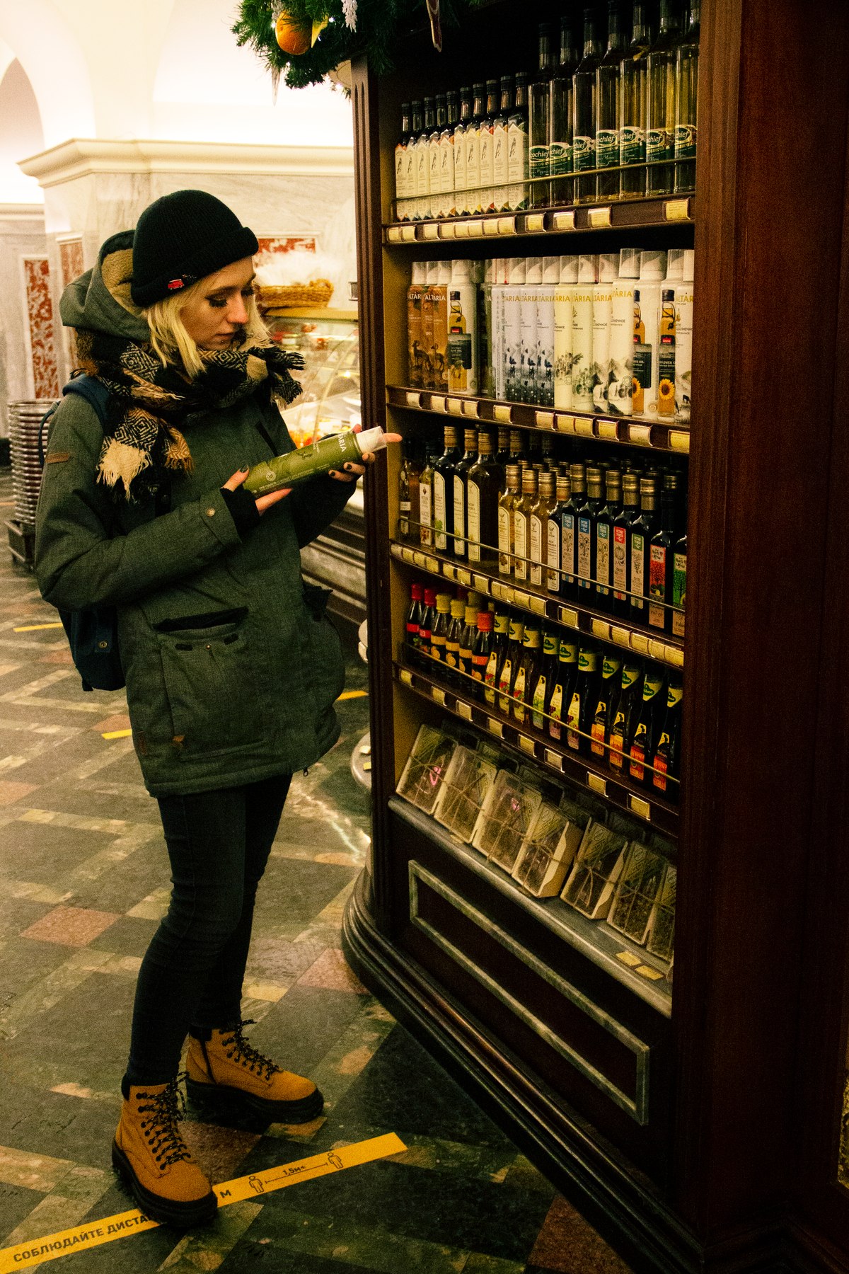 A shopper reading a food package in a grocery aisle.