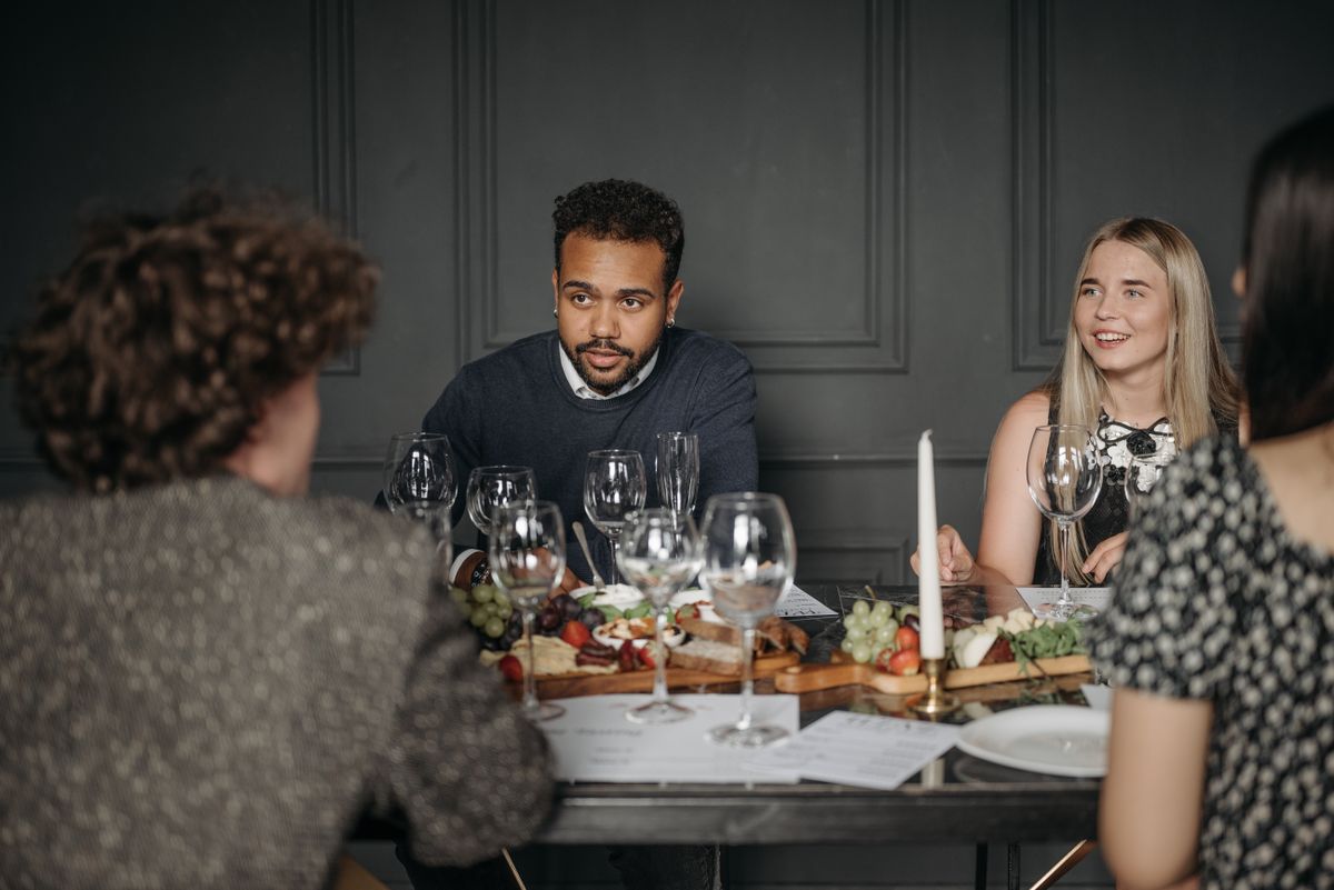 Guests sharing food around a dining table.