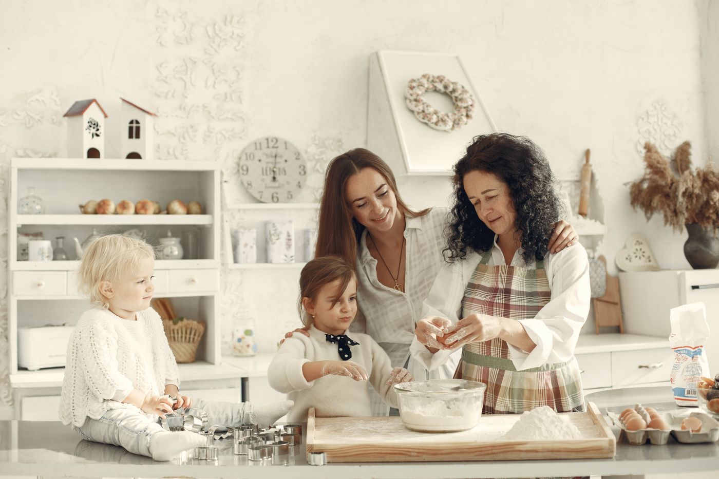 Three generations making dough in a kitchen