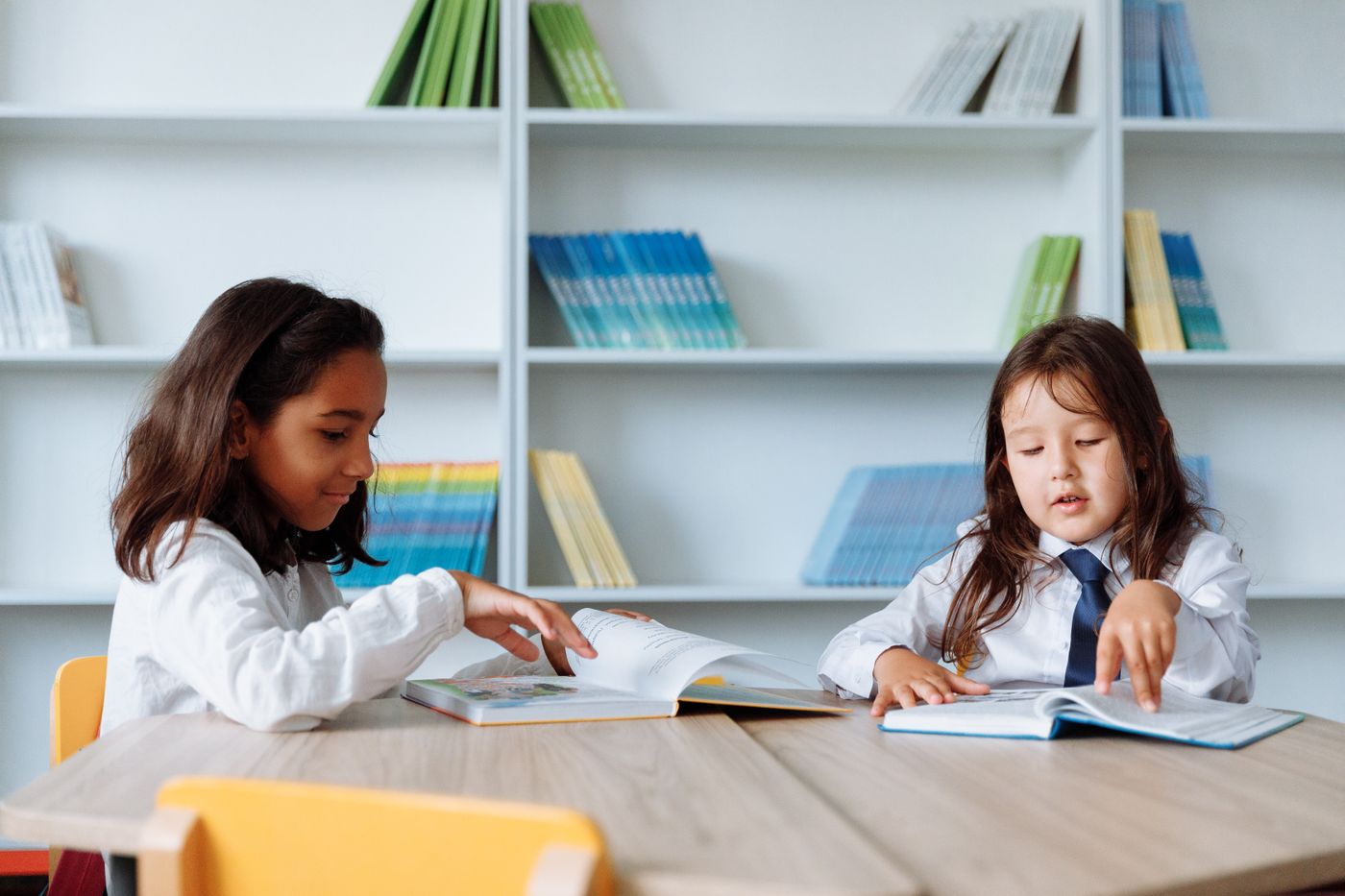 Two children reading books in a school library