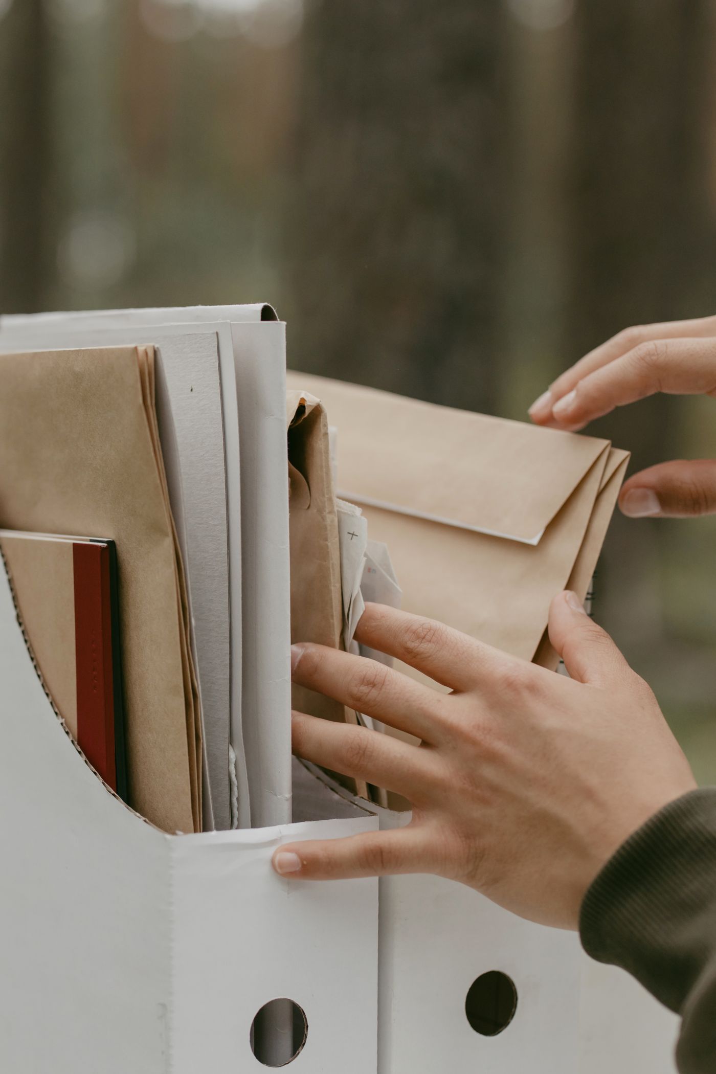Hands sorting paper folders in a file box