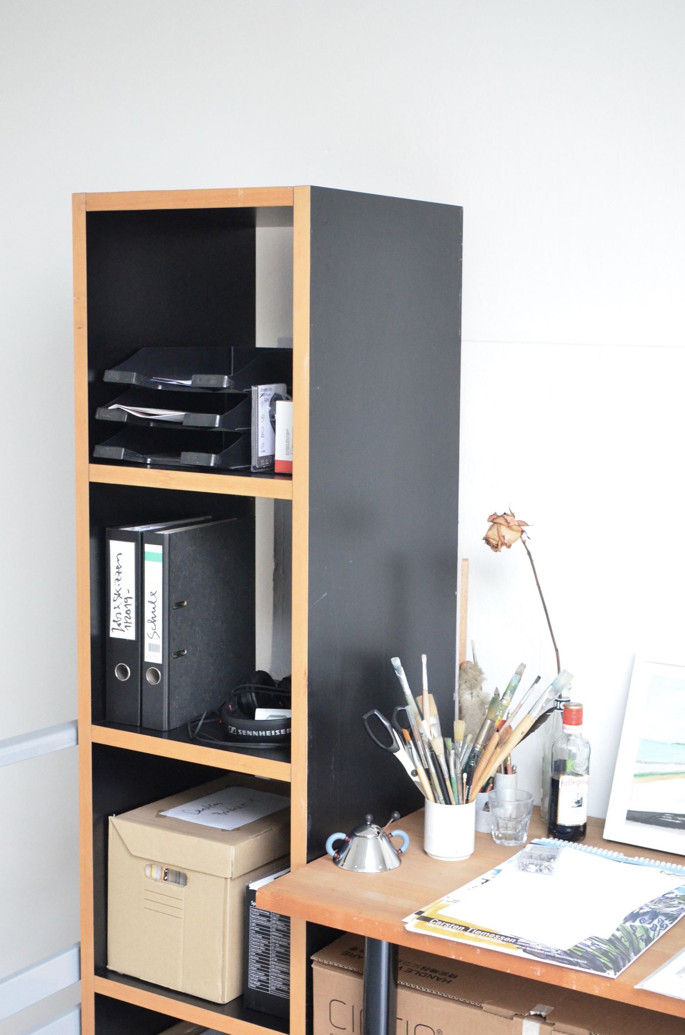 Documents and folders stored on shelves beside a desk