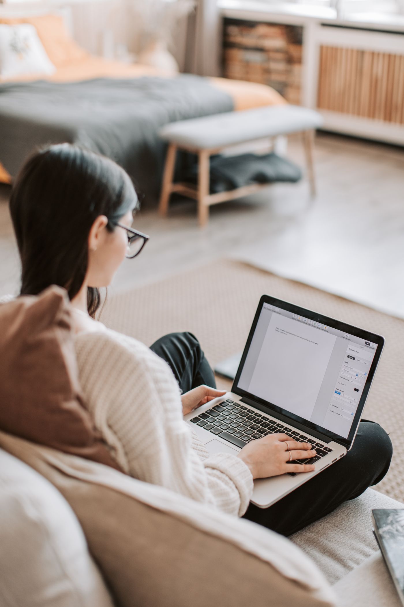 Hands typing on a laptop in a home setting