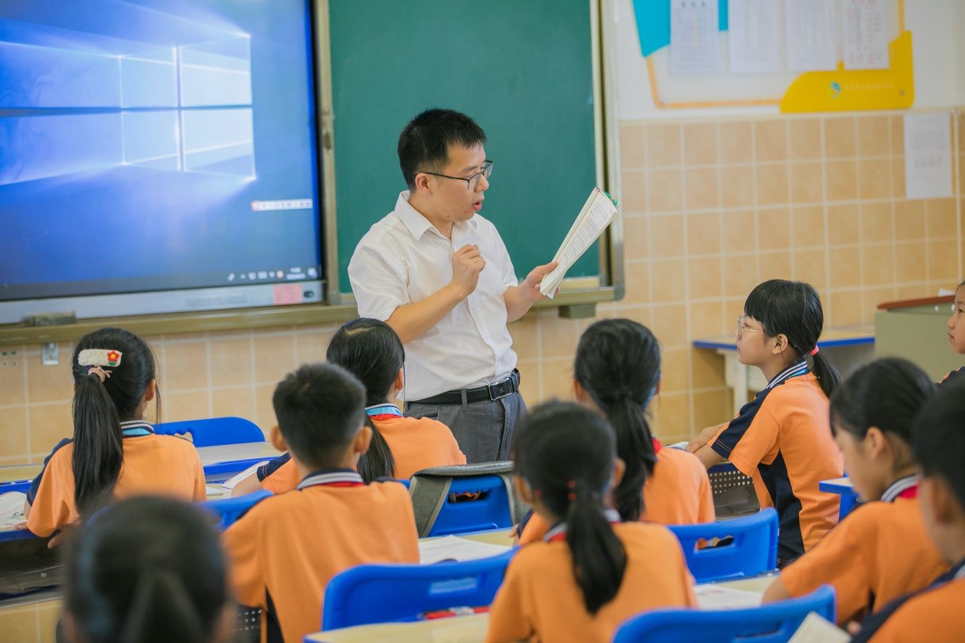 Children looking toward a teacher in a classroom