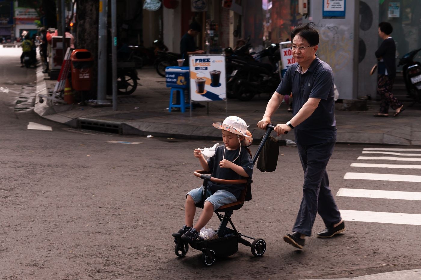 An adult and child at a city street crossing