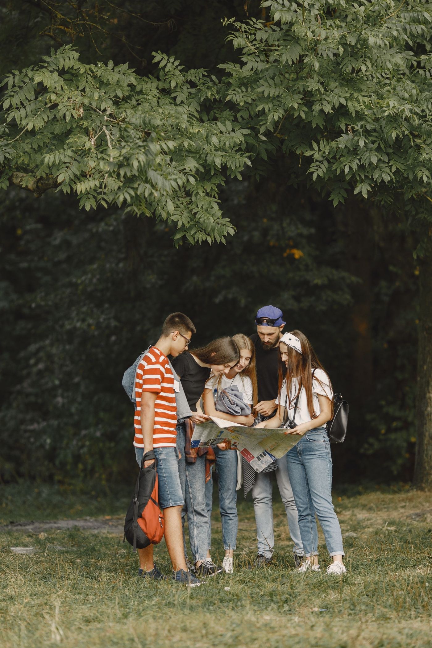 Young people studying a paper map outdoors