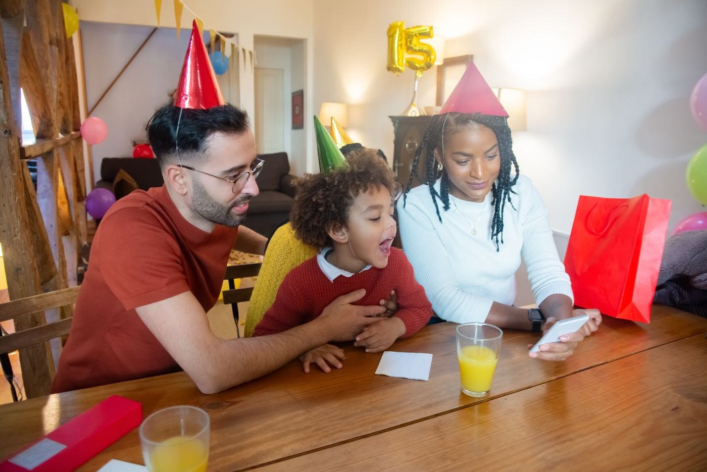 Adults and children wearing party hats during a video call